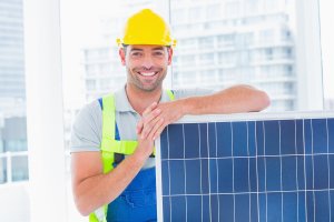 A team member from Solar Lights & More is standing with solar panels in Ocala, FL