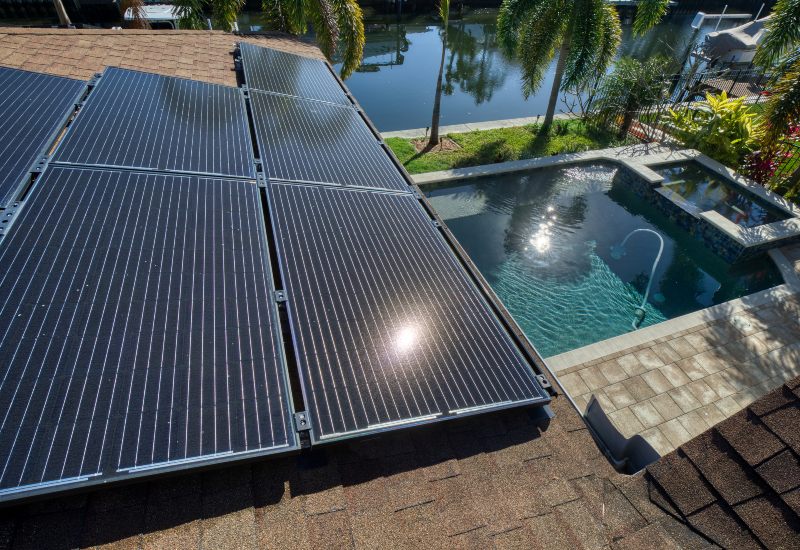 A Pool Heated by Solar Pool Heaters Installed on a House Roof
