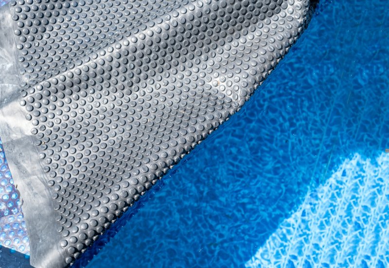 A Retractable Floating Solar Pool Cover Over a Swimming Pool